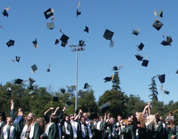 Graduates throwing mortarboards in the air