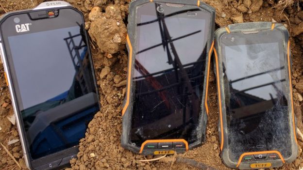 Phones on top of soil.