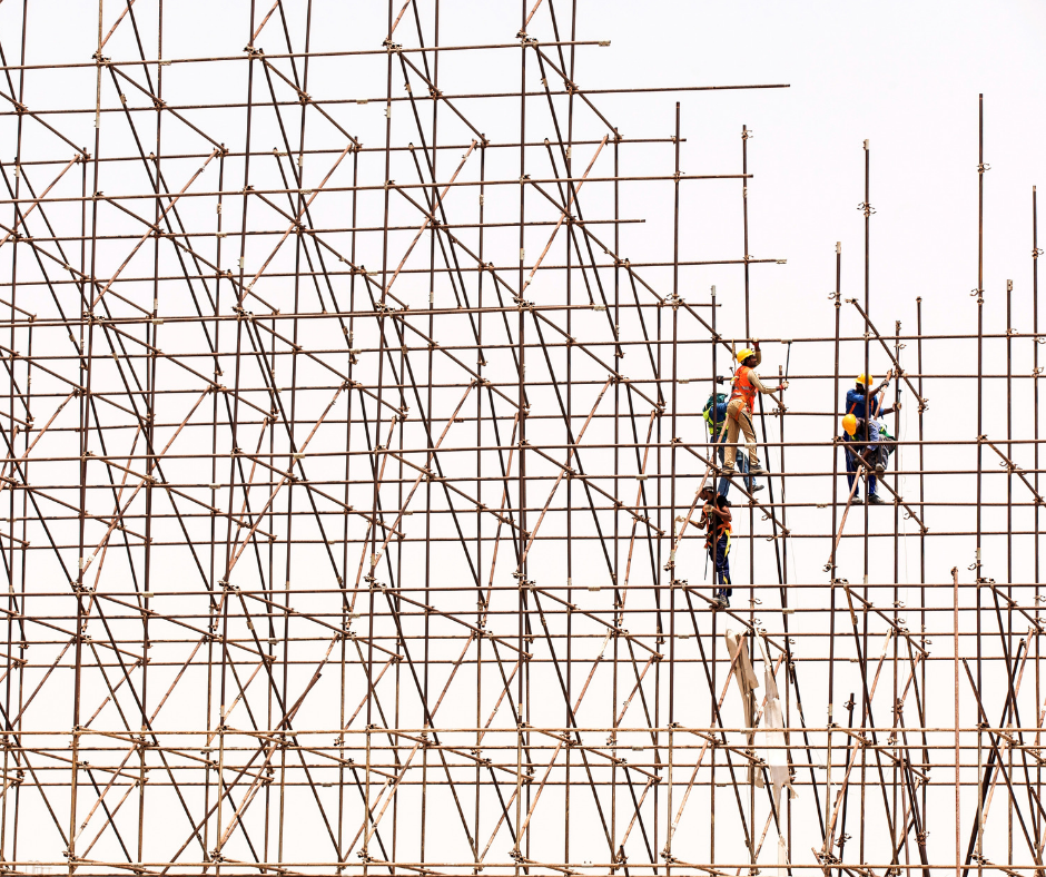 Construction workers working at height on scaffolds.