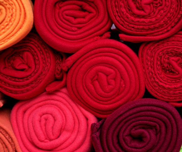 Rolled-up pieces of fabric in different shades of red.