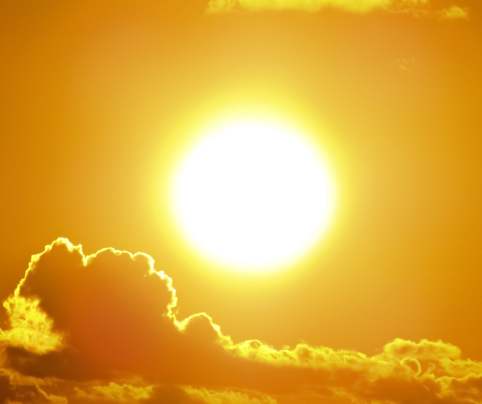 The sun shining brightly in the sky among clouds.