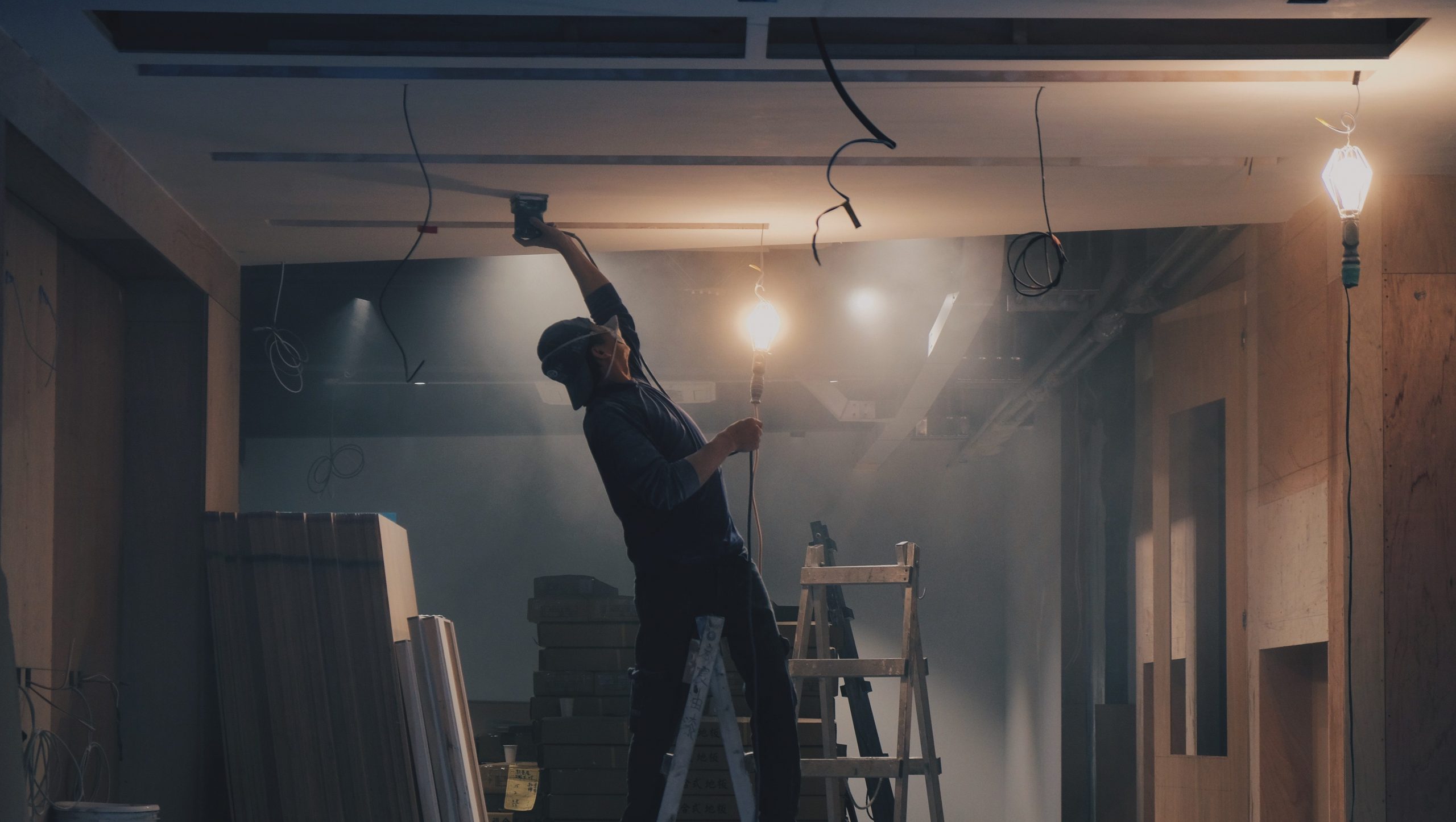 Dust being made visible in the air by a man hanging ceiling lights.
