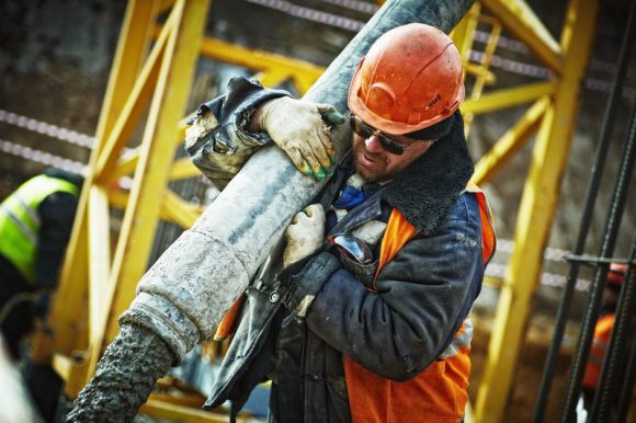 A worker carrying a piece of construction material.