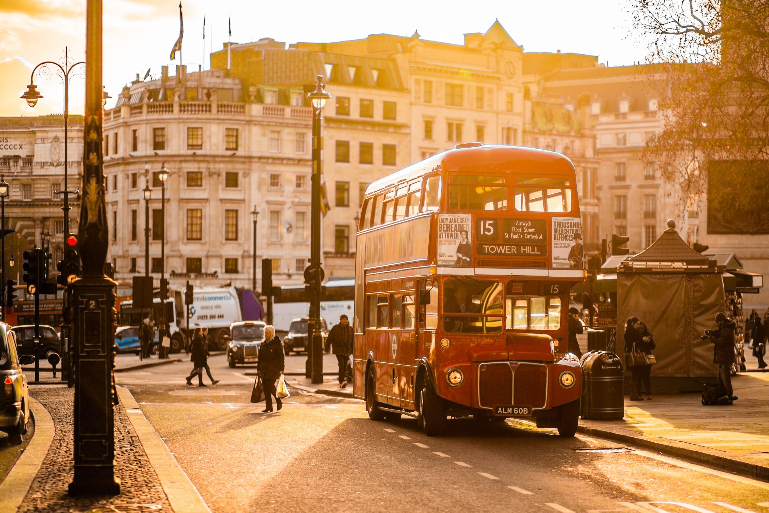A red double-decker bus in a busy city.