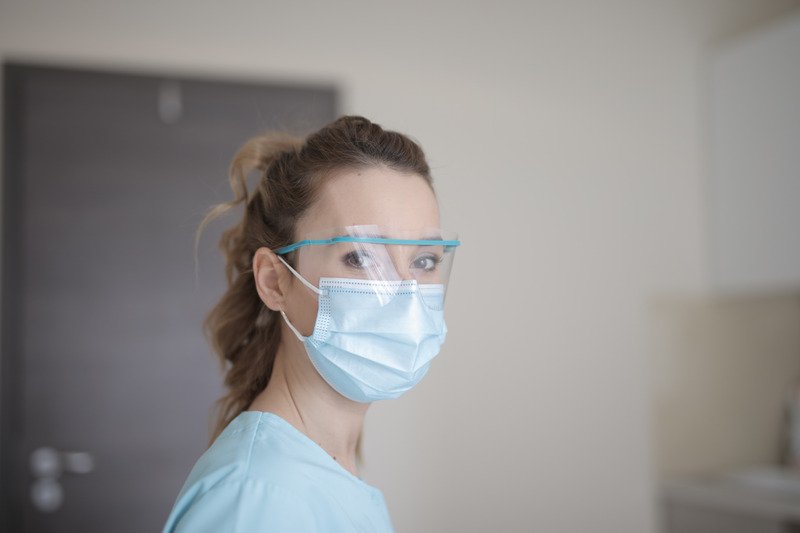 A medical worker wearing a face mask and protective eyewear..