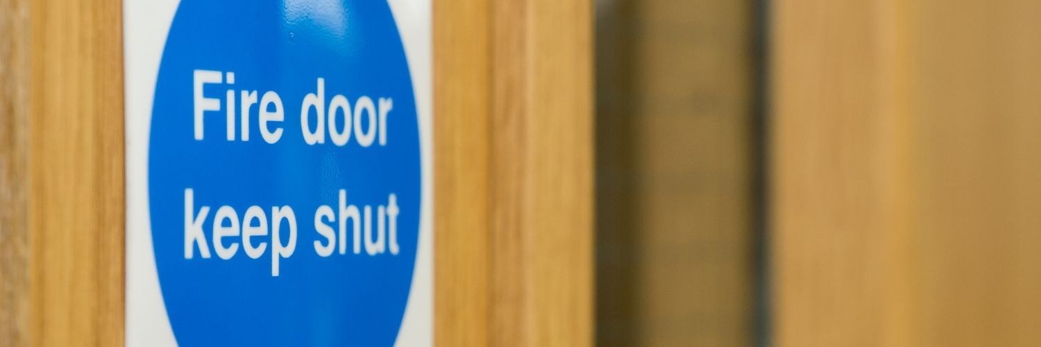 Close up of a fire door on the panel that reads 'Fire Door Keep Shut'