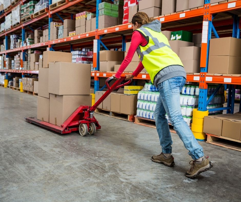 Worker pushing boxes in a warehouse