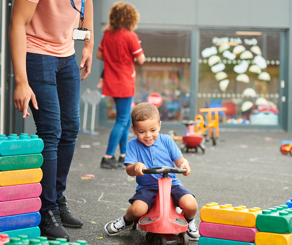 Nursery worker with child in playground