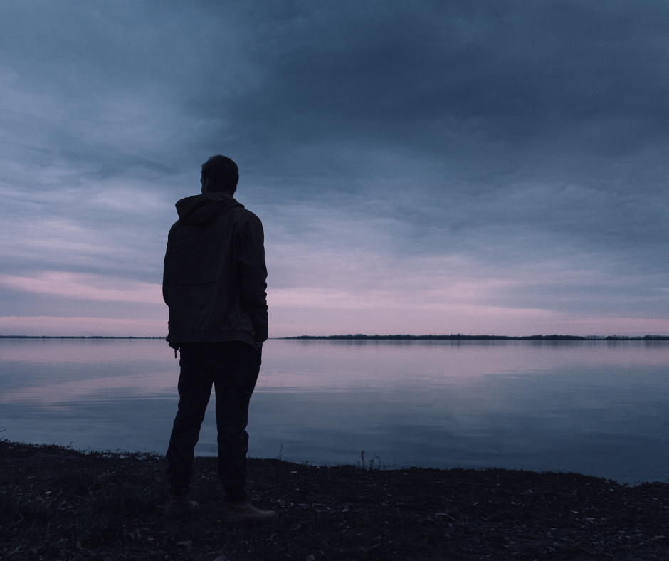 Person standing in front of a body of water